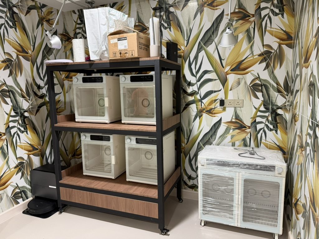 Drying cabinets on a rolling rack against a botanical tiled wall