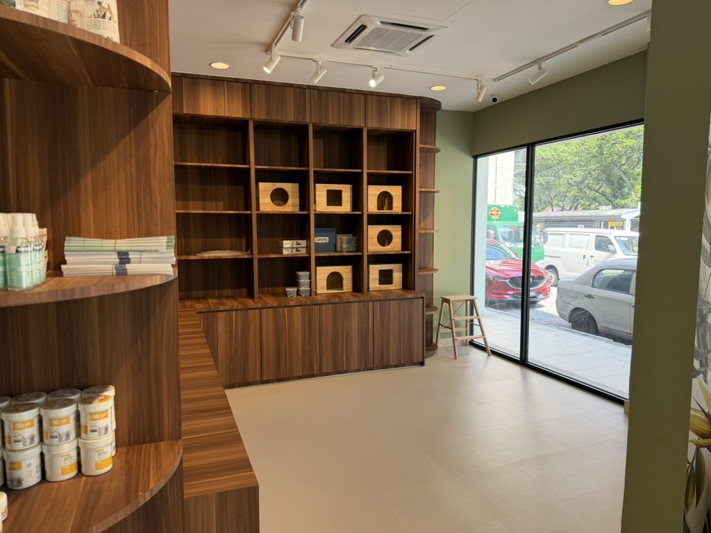 The retail area, with care products on curved wooden shelves and a large street-facing window